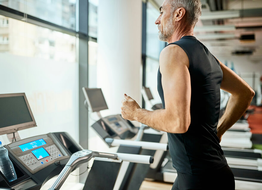 A mature athletic man running on a treadmill