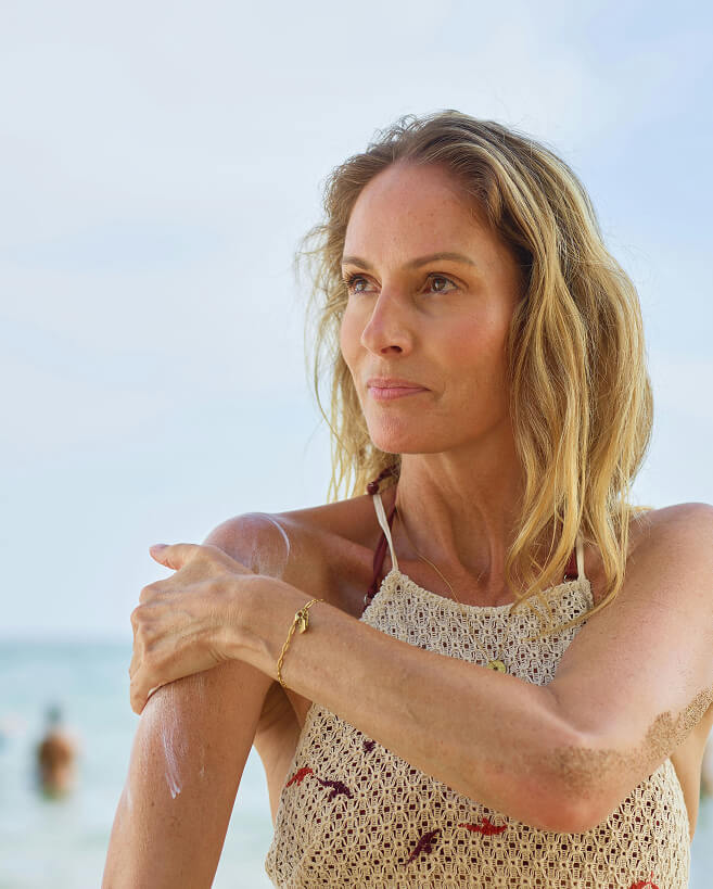 Middle aged woman apply sunscreen