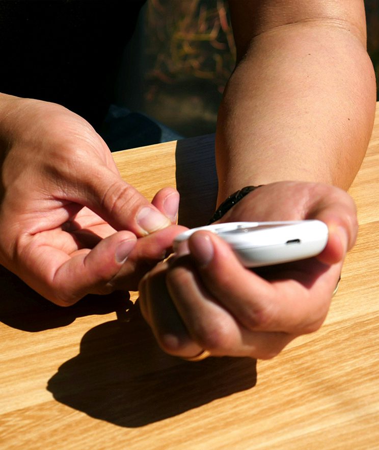 A person using a blood glucose monitor