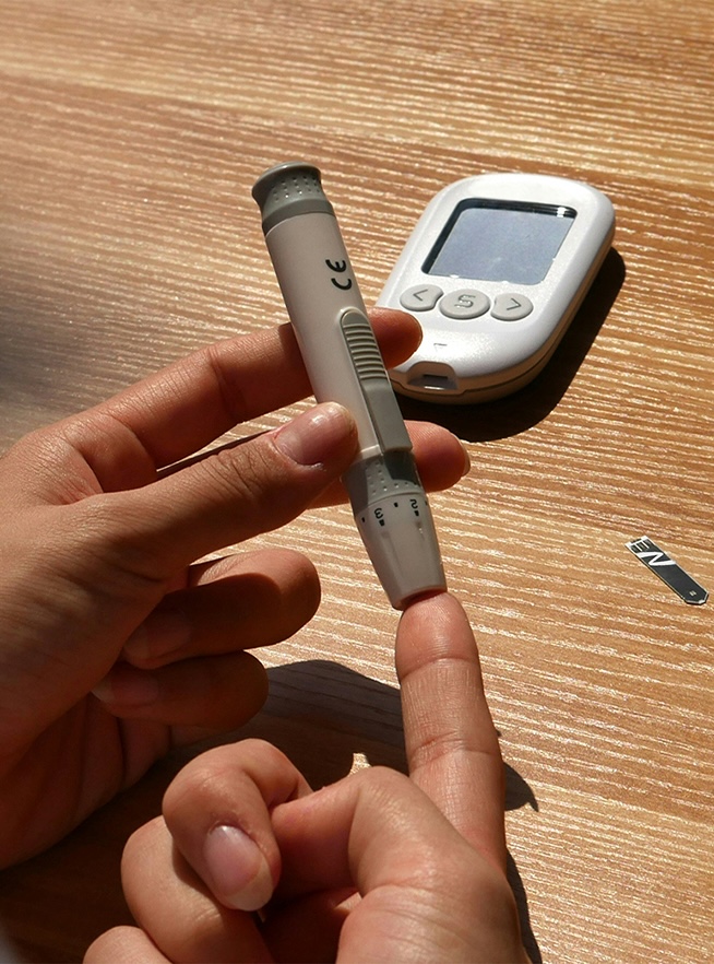 A person using a blood glucose monitor
