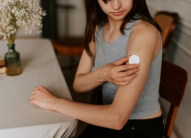 A woman with a continuous glucose monitor on her arm