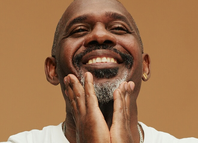 Man smiling touching his face