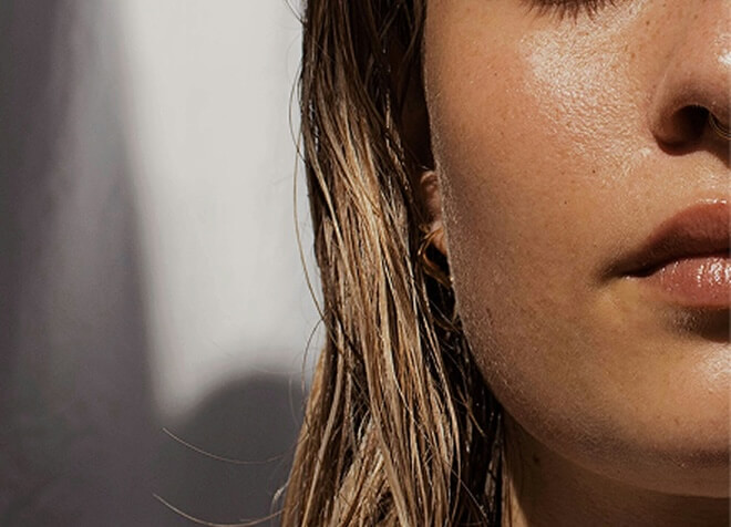 A close-up of a person with wet hair, highlighting textured skin