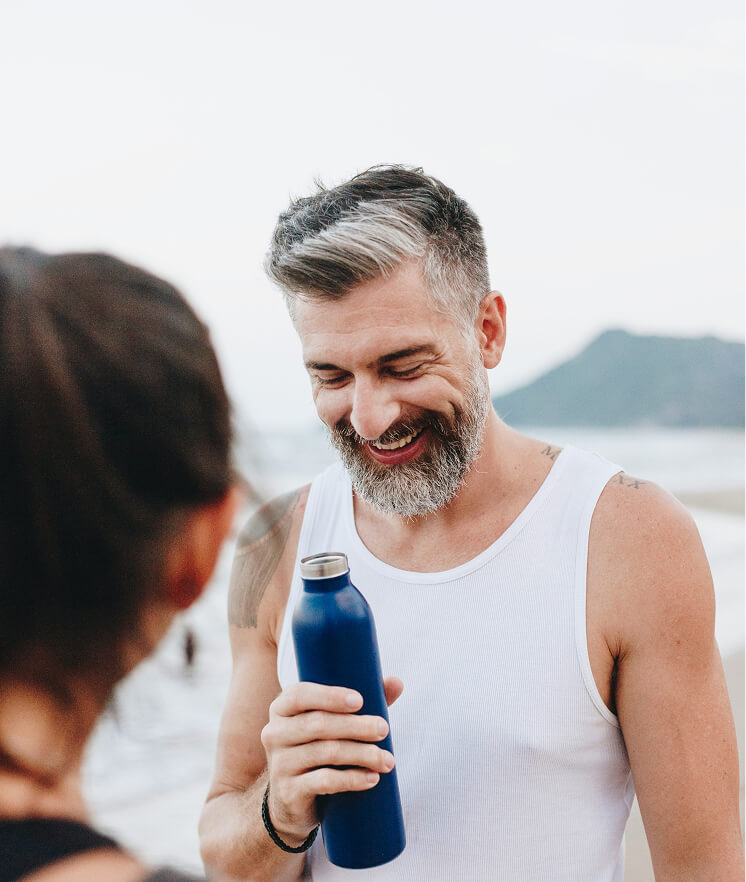 Man smiling and holding a water bottle