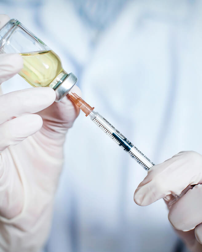 A person preparing to inject a medication