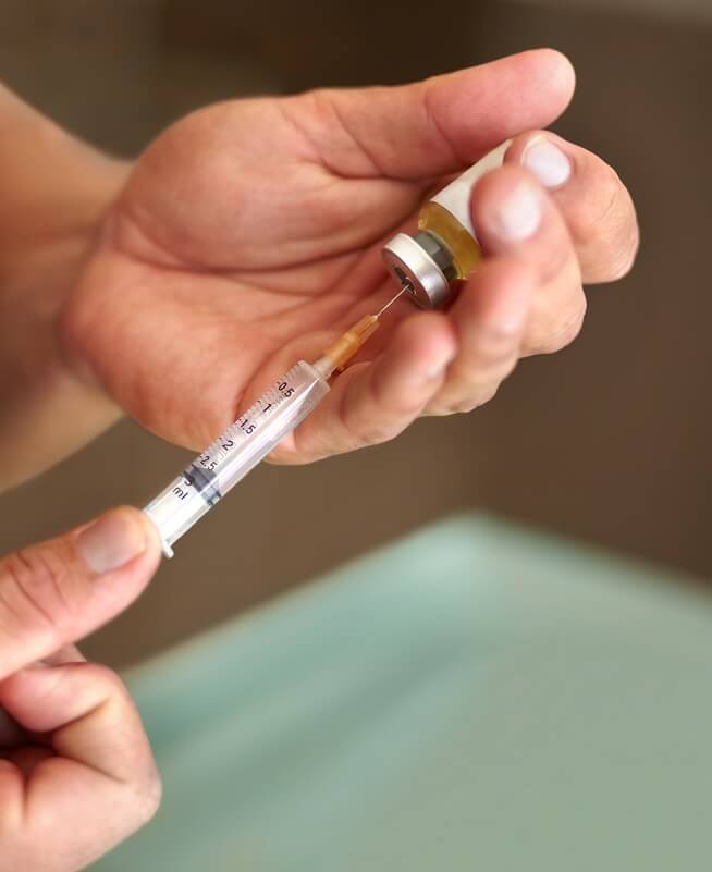 A person preparing to inject a medication